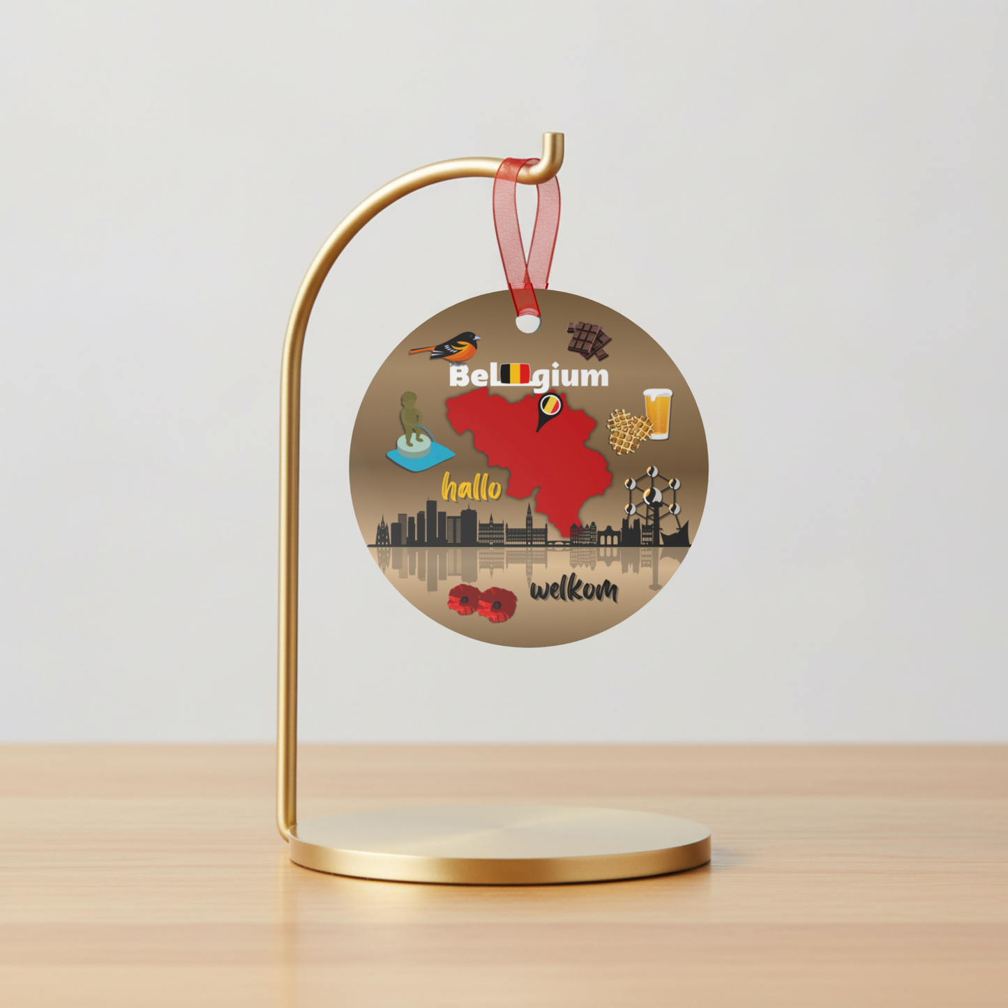 Decorative round ornament with Belgium-themed illustrations on a gold stand against a light gray background.