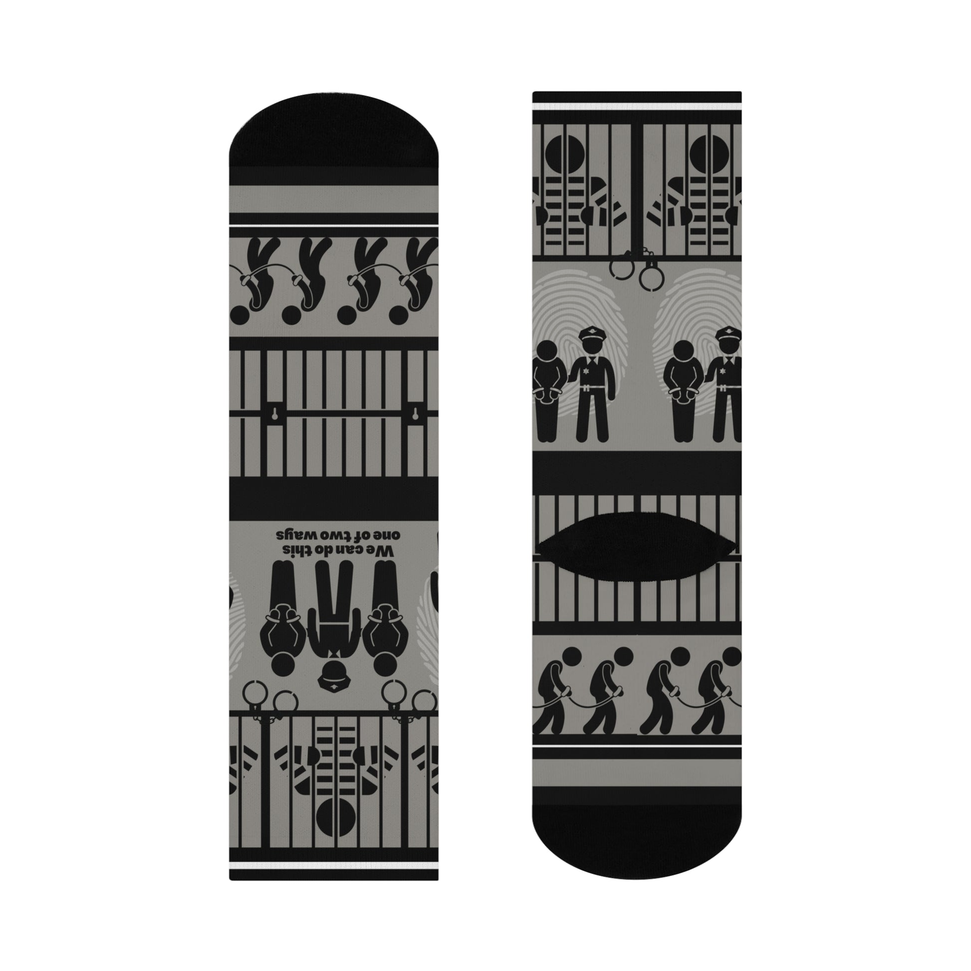 A pair of black and white crew socks with a geometric pattern, featuring designs that include cubes and what appears to be a representation of a police station or jail.