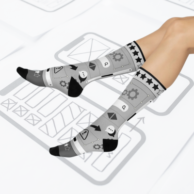 A pair of gray socks with a design of stars, gears, and other graphic elements related to user experience (UX) design.