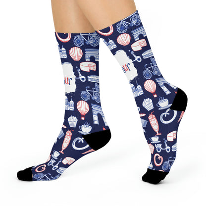 A pair of blue and navy colored socks with a design featuring French motifs such as the Eiffel Tower, a chocolate dessert, and other cultural elements.