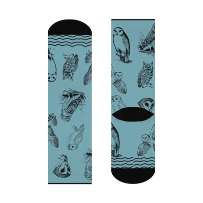 A pair of blue socks with owl patterns, designed for mid-calf coverage.